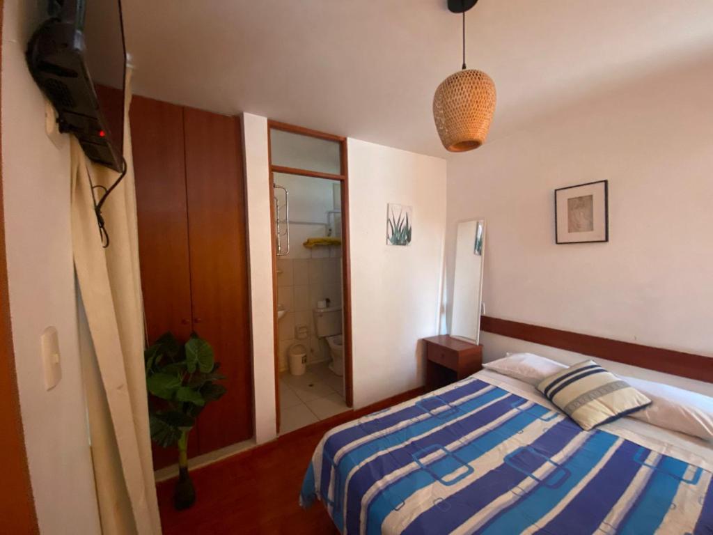 1 dormitorio con cama, espejo y baño en Hostal Pacasmayo Beach, en Pacasmayo