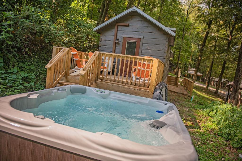 a hot tub in front of a wooden house at Ernie Cabin Wauhatchie Woodlands Tiny Cabin in Chattanooga