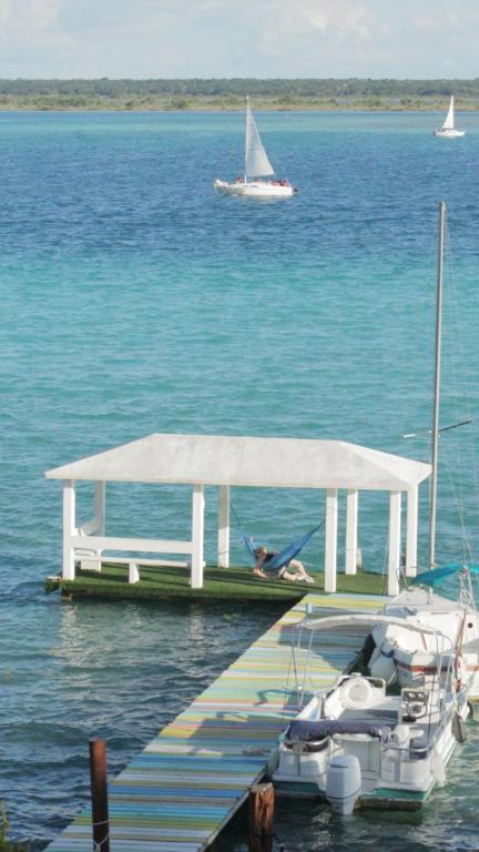 um barco está ancorado numa doca na água em Tropic Bacalar em Bacalar