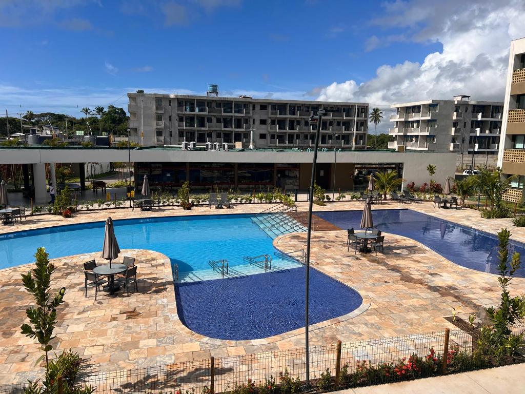 uma grande piscina em frente a um edifício em Flat Mana Beach Pono 216 na Praia de Muro alto em Ipojuca