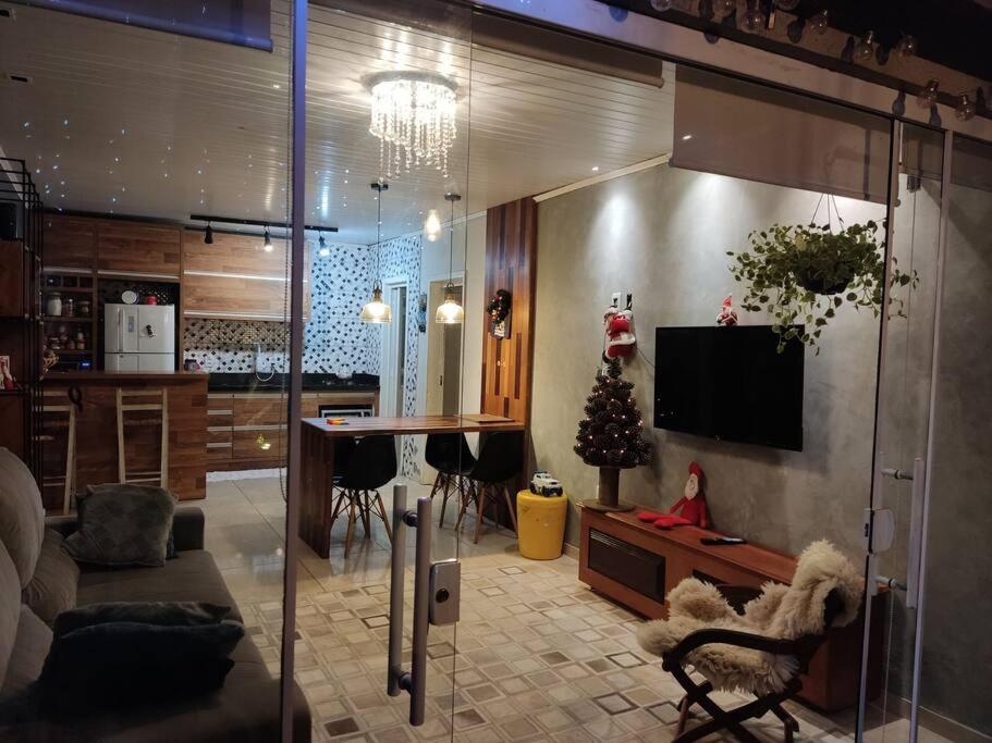 a living room with a television and a dining room at Casa na praia p aproveitar com a família e amigos in Capão da Canoa