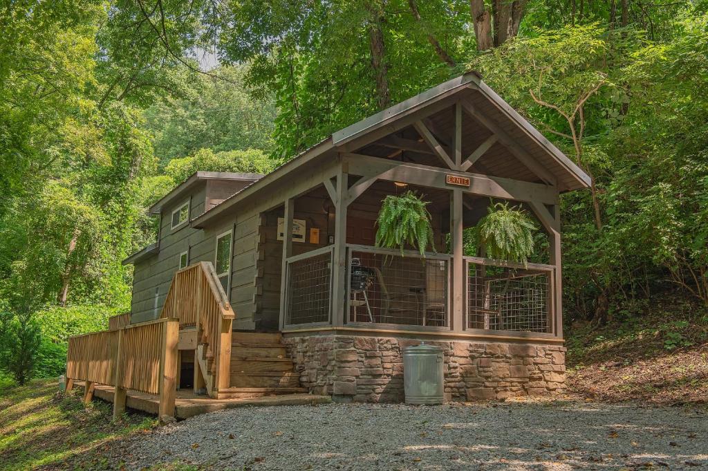 a cabin in the woods with a porch and a staircase at Ernie Cabin Wauhatchie Woodlands Tiny Cabin in Chattanooga