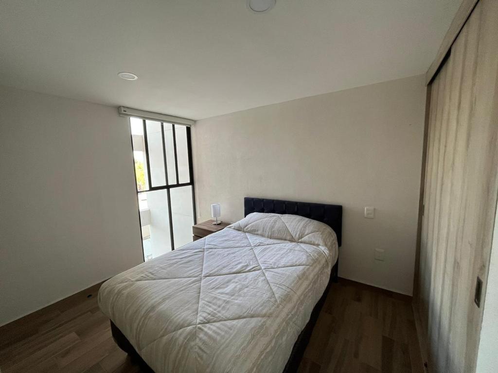a bedroom with a bed and a large window at Departamento nuevo a 5 cuadras de Roma Norte in Mexico City