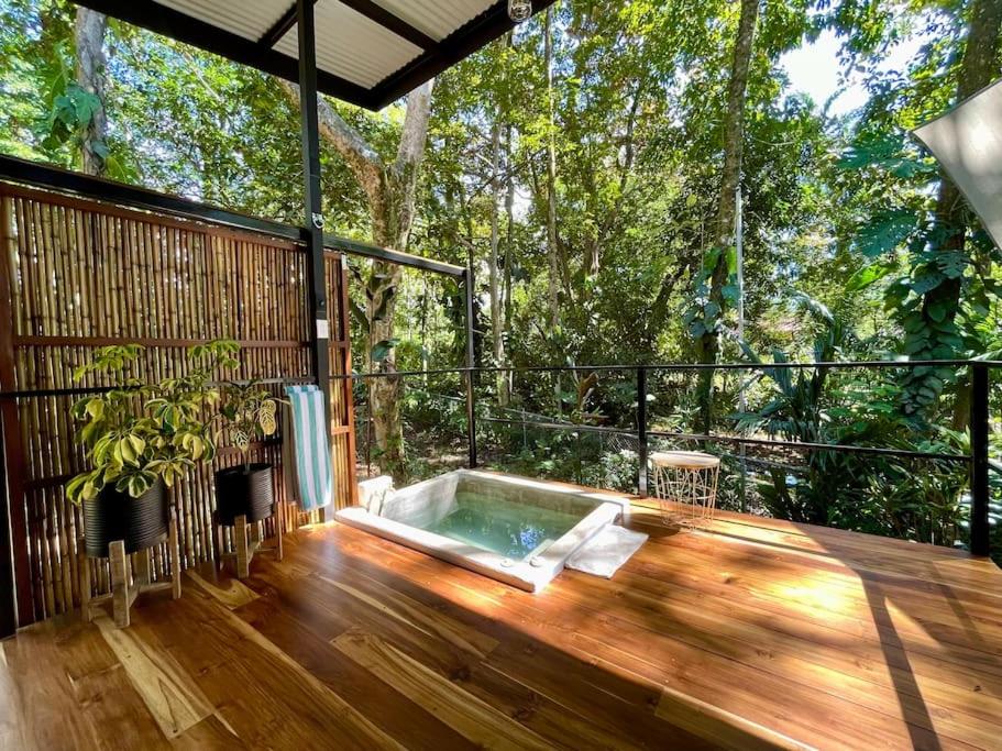bañera de hidromasaje en una terraza de madera con árboles en Industrial Studio with private Jacuzzi, en Uvita
