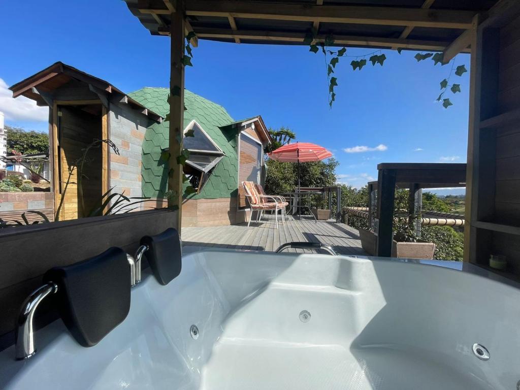 a bath tub with a sink in front of a house at Vitta Glamping in Rionegro