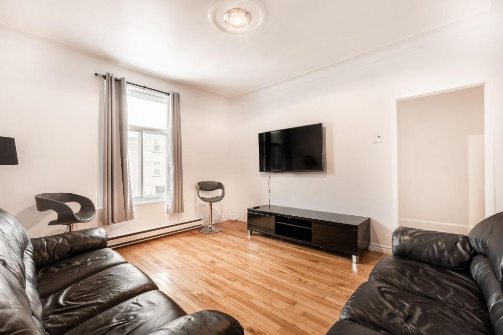 a living room with a couch and a flat screen tv at 3 bedroom apartment in Verdun in Montreal