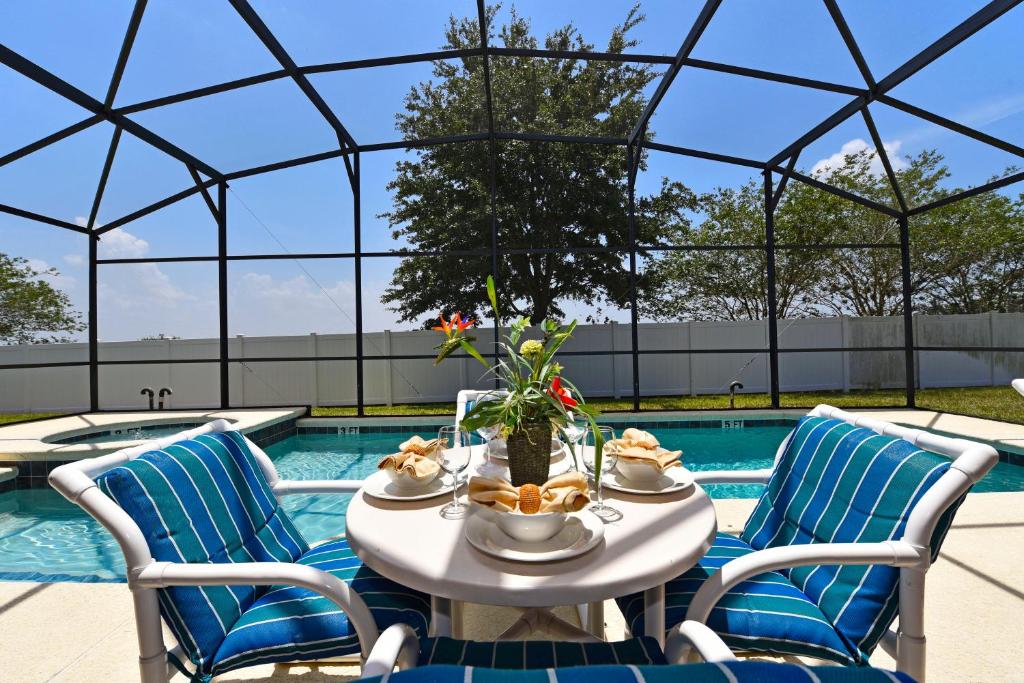 una mesa con un tazón de comida junto a una piscina en Family Friendly Home, South-facing Pool,Spa, Gated Resort near Disney -928, en Davenport