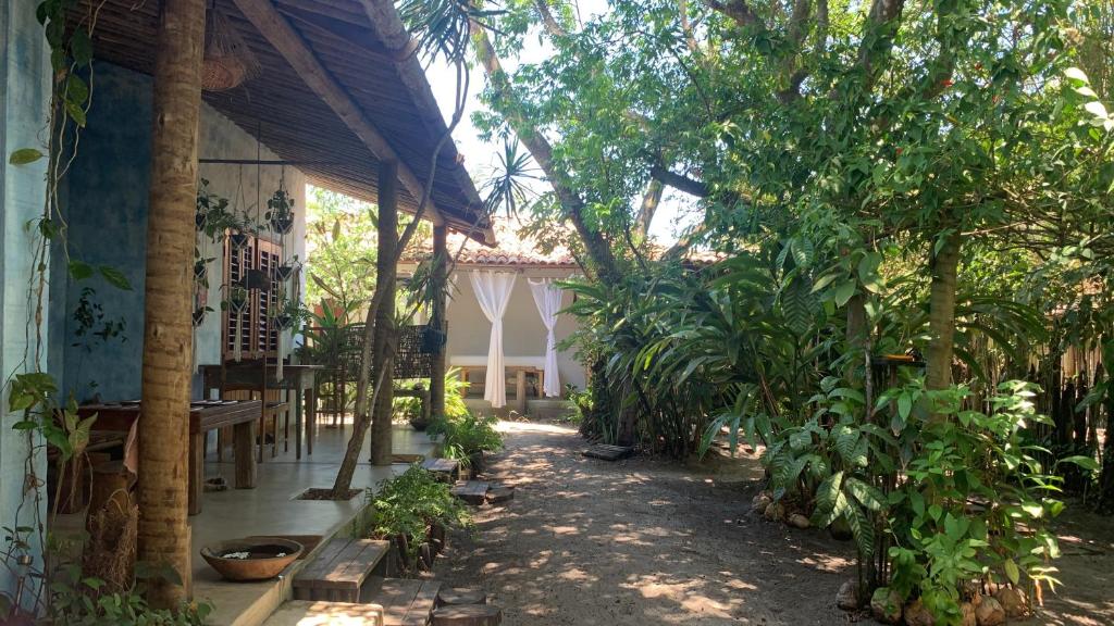 una casa con alberi e piante in un cortile di Pousada Spa Oasis a Caraíva