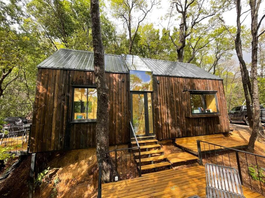 Cabaña de madera en el bosque con terraza en Acogedora cabaña con tinaja libre para disfrutar, en Las Trancas