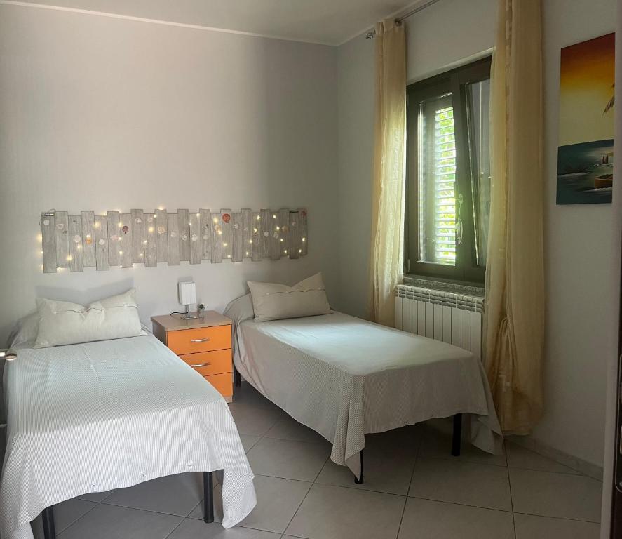 Un dormitorio con 2 camas y una ventana con luces. en Villa with Stunning Sea View Zambrone, en Mandaradoni