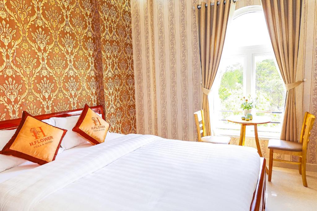 a hotel room with a bed and a window at H Flower Hotel and Villa Đà Lạt in Da Lat
