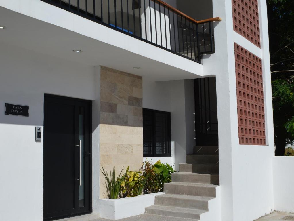 a staircase leading up to a house with a black door at Departamentos DOS21 in Mazatlán
