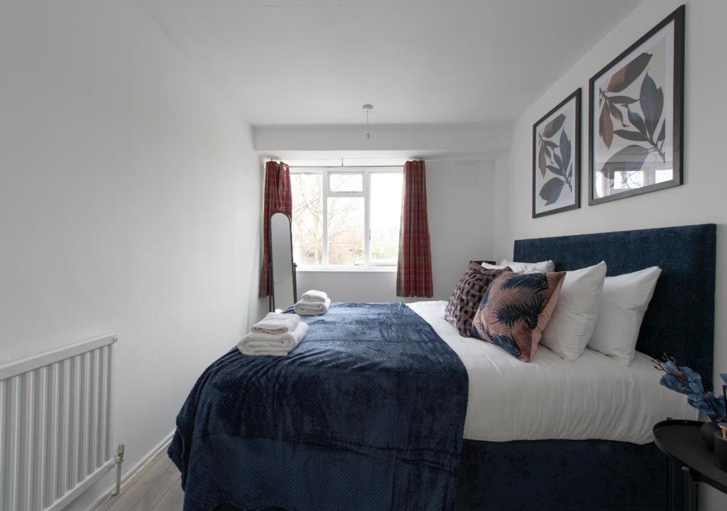 sypialnia z dużym łóżkiem i niebieskim kocem w obiekcie Prime London Location 3-Bed Flat w Londynie