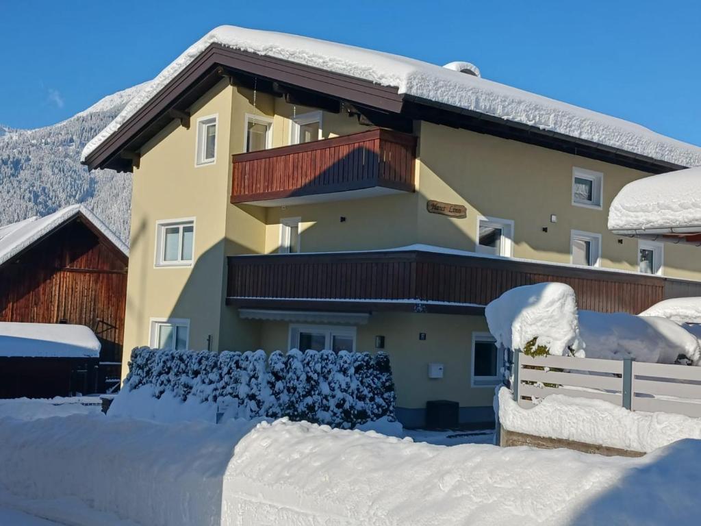 una casa cubierta de nieve con una valla en Haus Linn, en Ehrwald