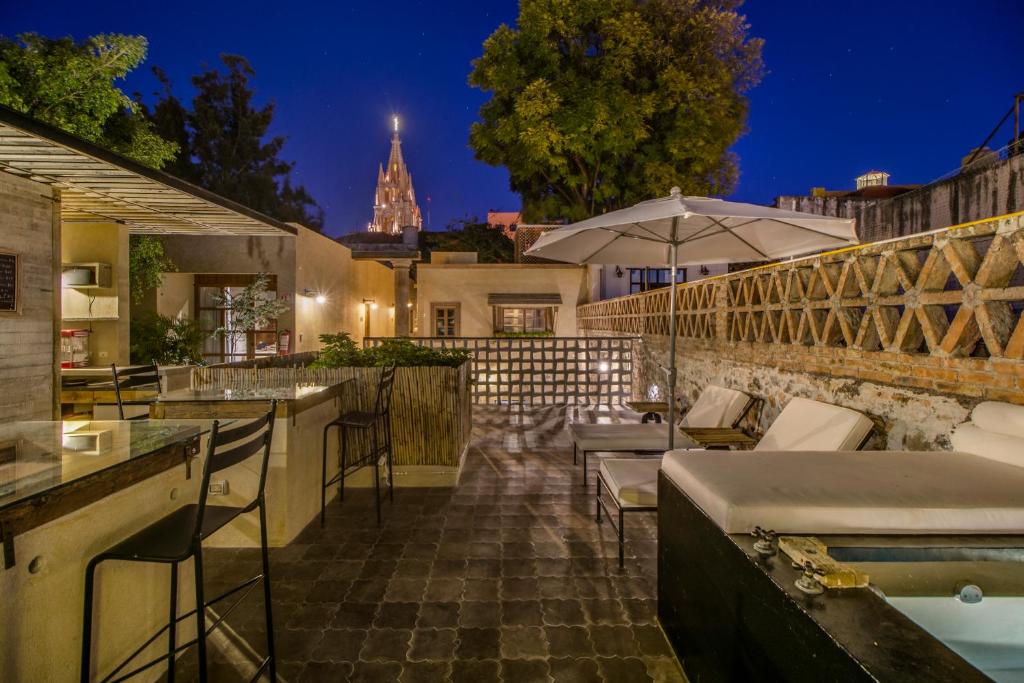 an outdoor bar with chairs and an umbrella at Casa Andreu in San Miguel de Allende