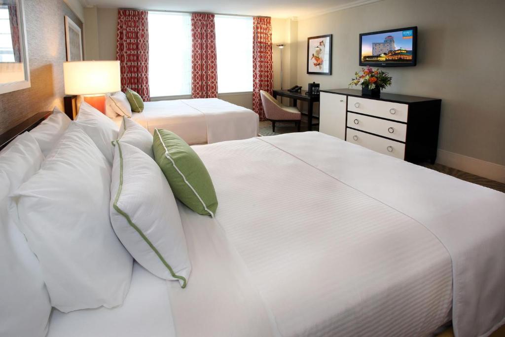 a hotel room with two beds and a desk at Cozy Unit at Resort Casino Hotel Atlantic City in Atlantic City