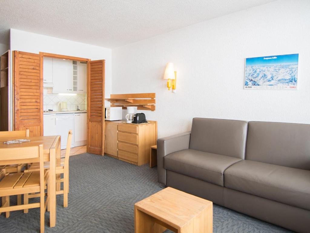 un salon avec un canapé et une table et une cuisine dans l'établissement Studio cosy avec WiFi gratuit à 500m des pistes, Tignes - FR-1-449-138, à Tignes