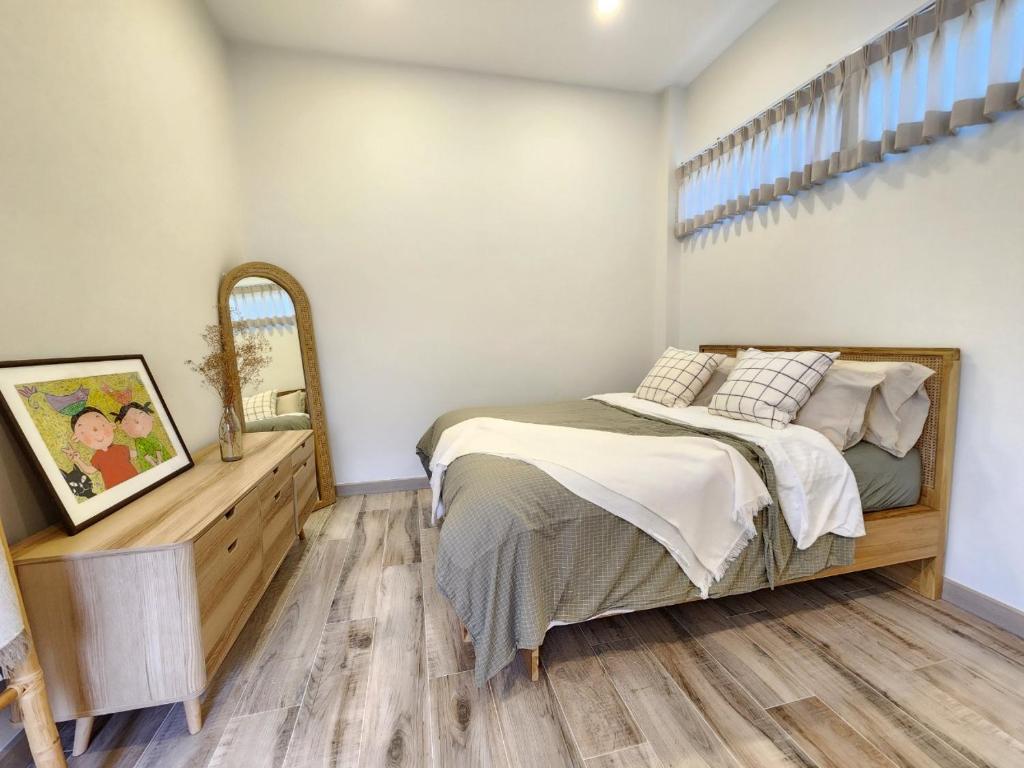 1 dormitorio con 1 cama y suelo de madera en Self house (Cozy private house) en Hat Yai