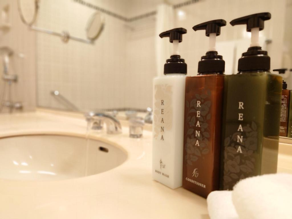 two bottles ofodorizers on a bathroom counter next to a sink at Rihga Royal Hotel Hiroshima in Hiroshima