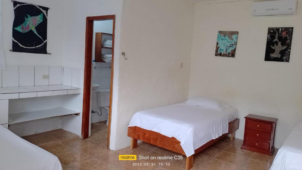 een kleine slaapkamer met een bed en een spiegel bij Lugar Tranquilo in Puerto Ayora