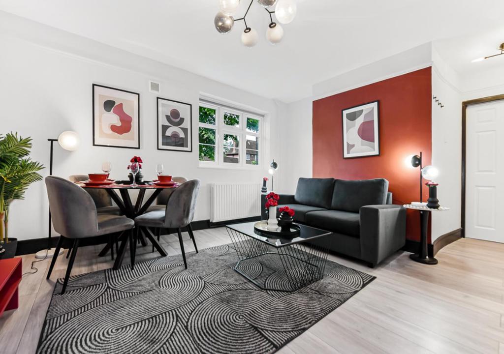 ein Wohnzimmer mit einem Tisch und einem Sofa in der Unterkunft Radiant Serenity: 2BR Flat Sleeps 5 -Warm Ambiance in London