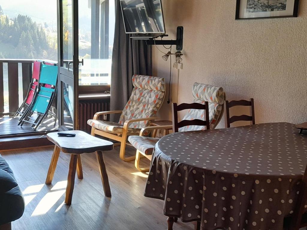 Cette chambre dispose d'une table, de chaises et d'un balcon. dans l'établissement 6 Personnes - Centre haut du village (OUB190) - FR-1-459-83, à La Clusaz
