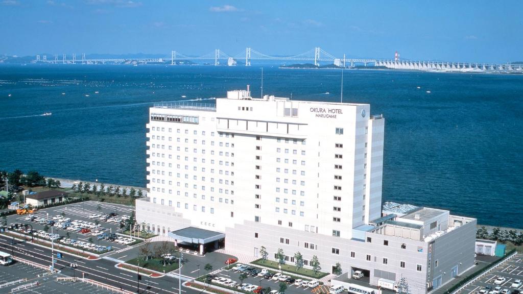 an aerial view of a large white building next to the water at Okura Hotel Marugame in Marugame