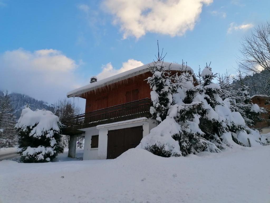 una casa cubierta de nieve con árboles delante en Chalet La Clusaz, 5 pièces, 6 personnes - FR-1-459-129 en La Clusaz