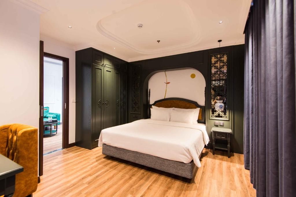 a bedroom with a white bed and black walls at Paradise Suites Nguyen Khuyen in Hanoi
