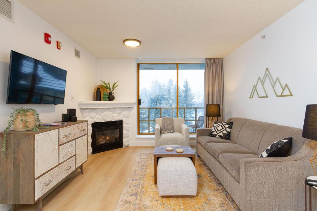 a living room with a couch and a tv and a fireplace at 600 SQFT 1 Bed 1 Bath Mountain View Suite at Cascade Lodge in Whistler Village Sleeps 4 in Whistler