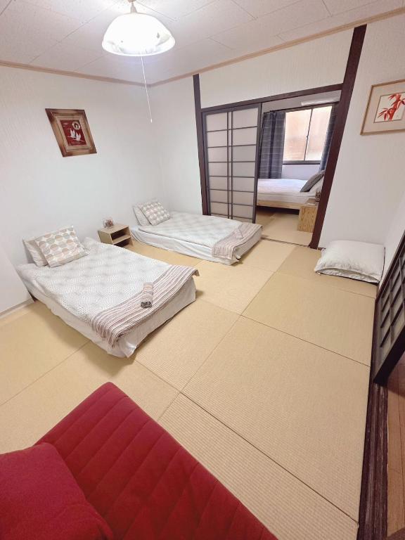 Säng eller sängar i ett rum på Nippori Osaka Nishi-Tengachaya Guesthouse西天下茶屋アパートメント