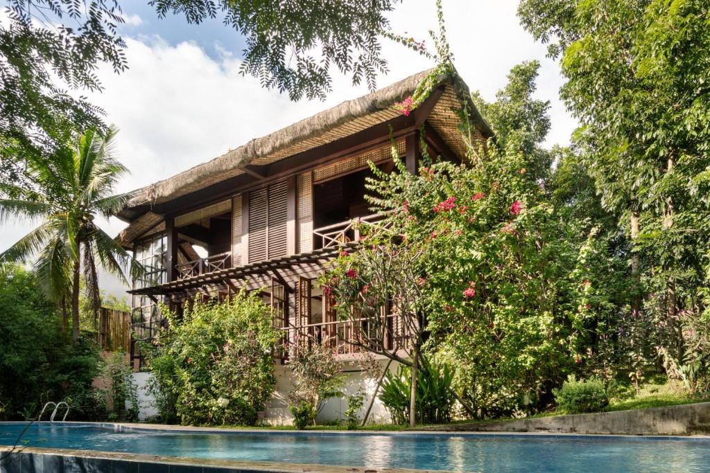 a house with a pool in front of it at The Red Hen Homestead in Batangas City