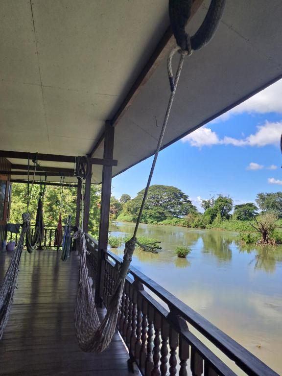 东德岛Riverside Bungalow Don Det的带吊床的门廊,眺望着河流