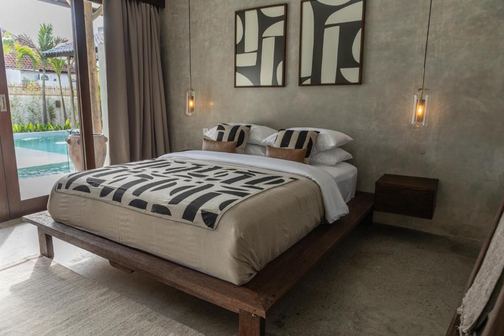 a bedroom with a large bed and a pool at Kano Twin in Canggu