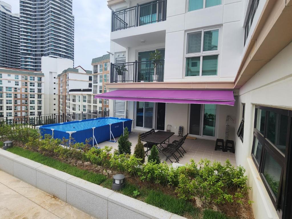 an apartment patio with a purple awning on a building at Ungcheon Hotel Travel Bag in Yeosu