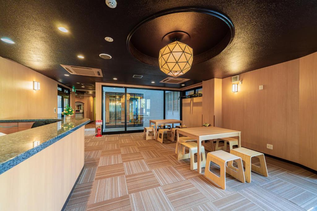 TOKYO E JOY INN （East Nipoori Branch） في طوكيو: لوبي به طاولات وكراسي وبار