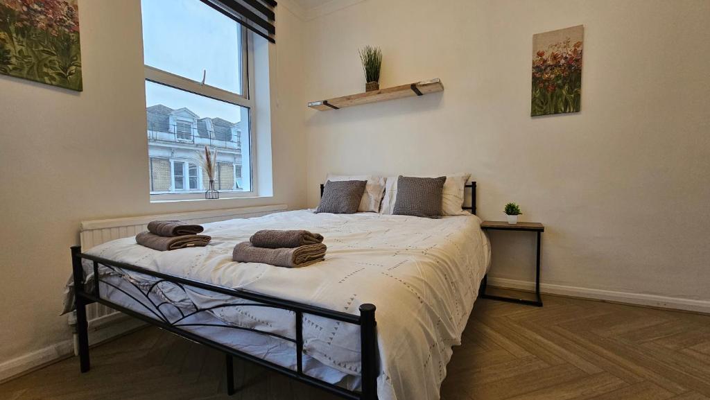ein Schlafzimmer mit einem großen Bett mit Handtüchern darauf in der Unterkunft Bros Inn Hotel in London