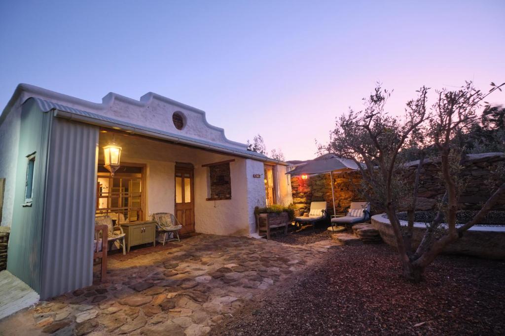 une maison avec une cour et une terrasse en pierre dans l'établissement Olive Stone Farm Cottages, à Montagu