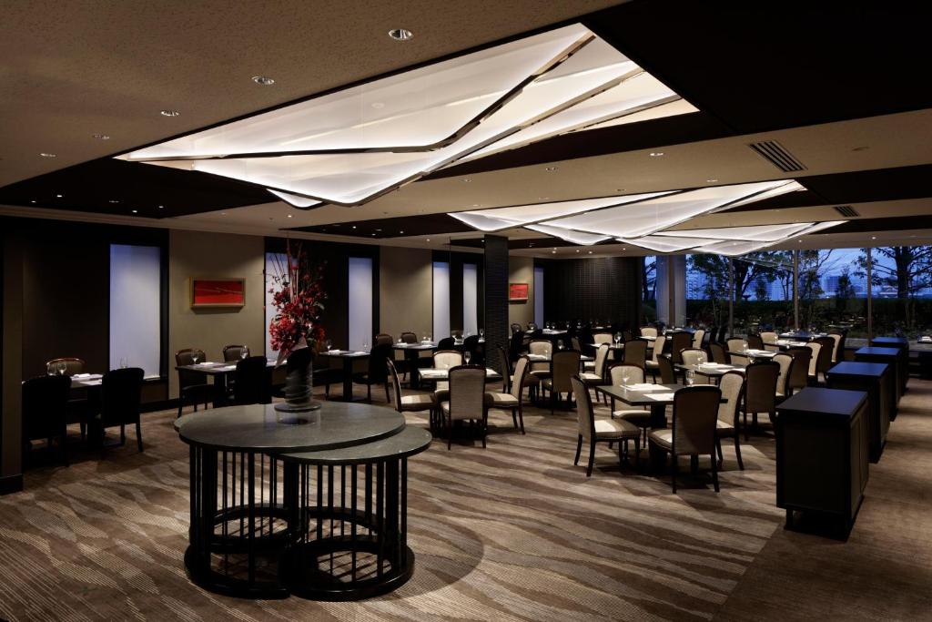 a restaurant with tables and chairs in a room at Rihga Royal Hotel Hiroshima in Hiroshima