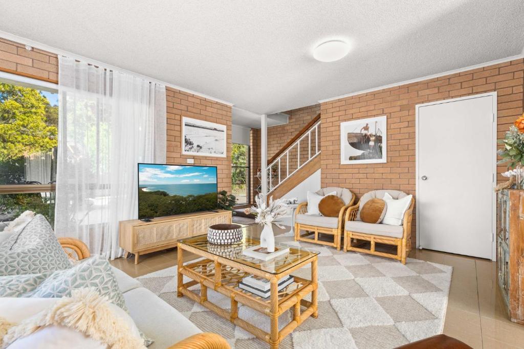a living room with a couch and a tv at Samos by Experience Jervis Bay in Huskisson