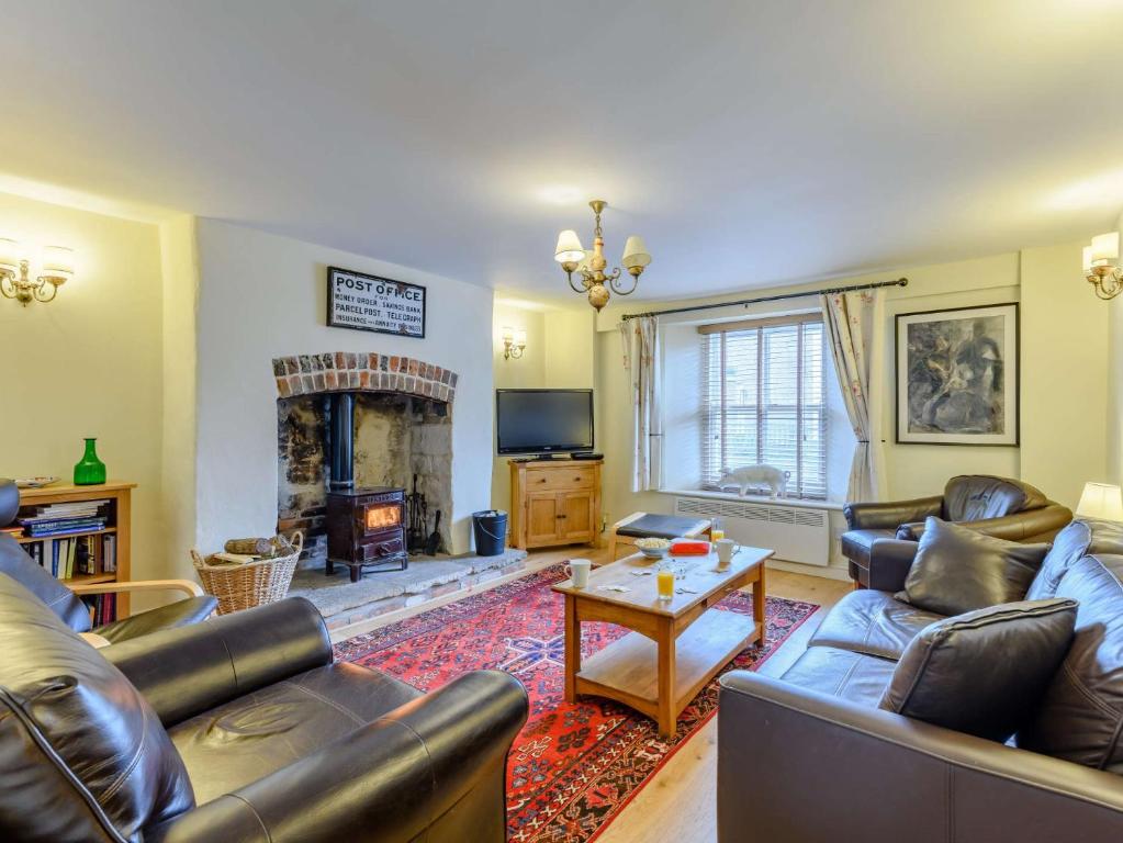 a living room with leather furniture and a fireplace at 3 bed property in Bridport 75334 in Frome Vauchurch