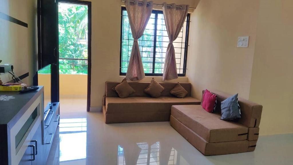 a living room with a couch and a large window at UDUPI G01 HOMESTAY in Udupi