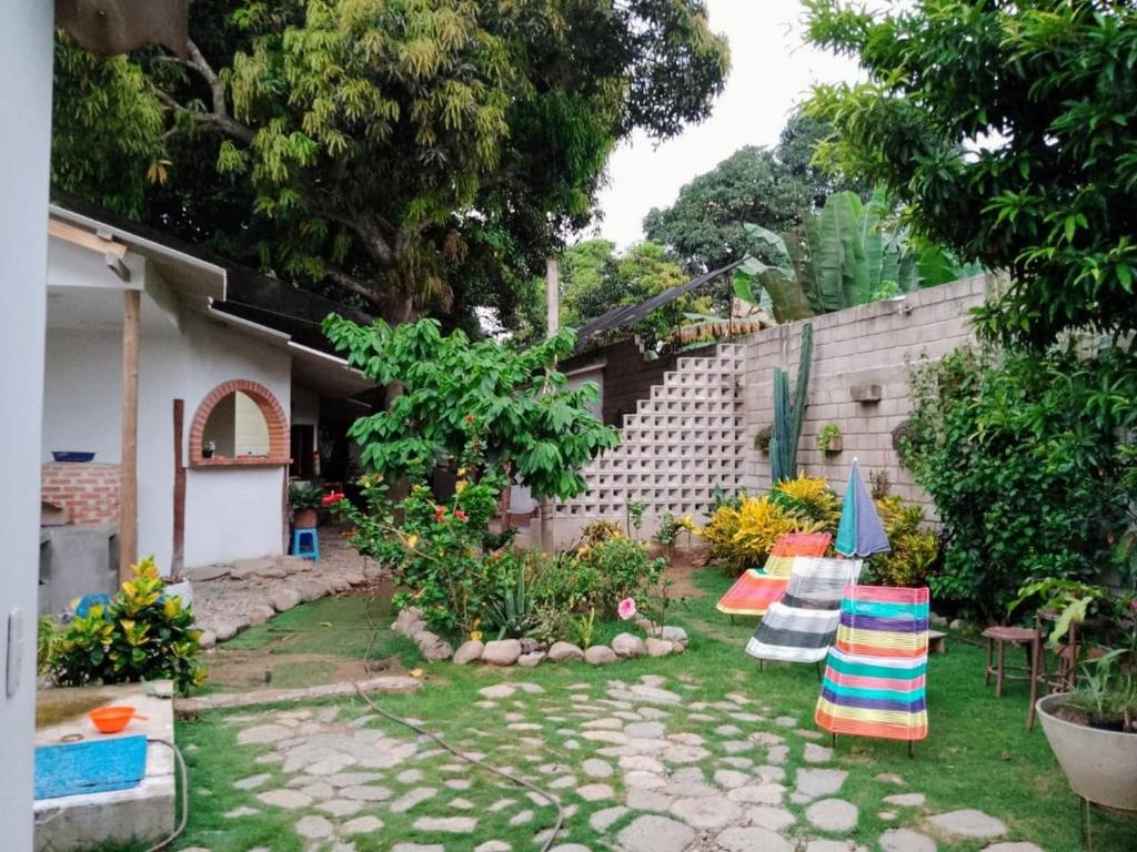 einen Garten mit Stühlen, einem Tisch und einem Gebäude in der Unterkunft Hermoso Palomino in Palomino