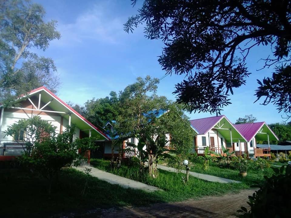 uma fila de casas com telhados roxos em สวนทุเรียน นันนัน มีดี รีสร์อท 