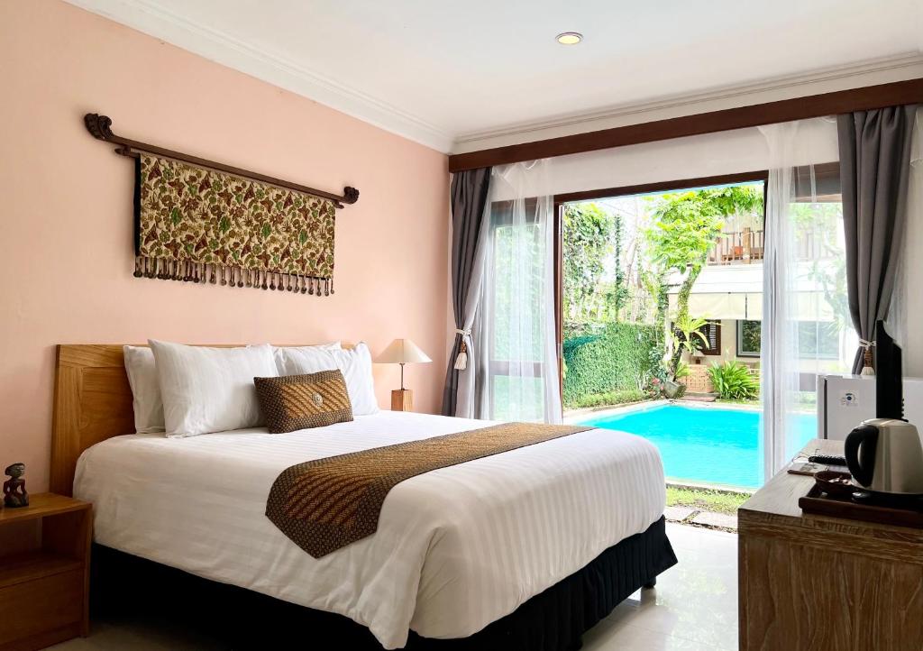 a bedroom with a large bed and a large window at Villa Puriartha Ubud - CHSE Certified in Ubud