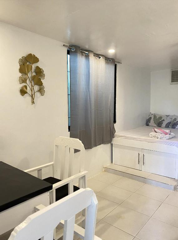 Cette chambre comprend un lit et deux chaises blanches. dans l'établissement Casa Luna 3 by Angelito's, à General Luna