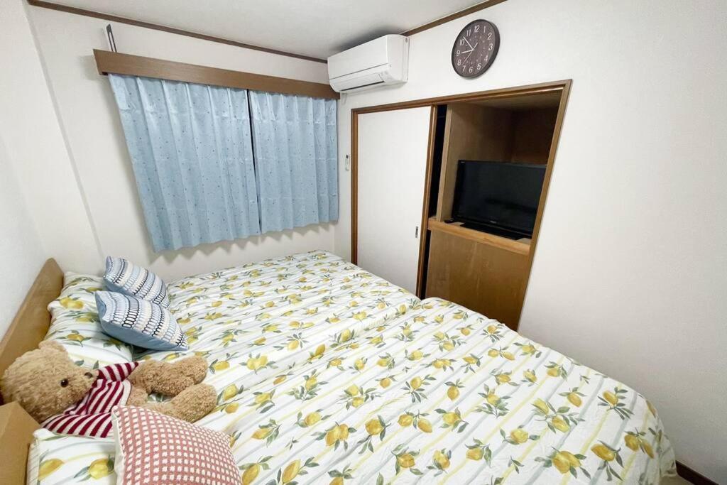 a bedroom with a bed with two teddy bears on it at Rainbow House in Osaka