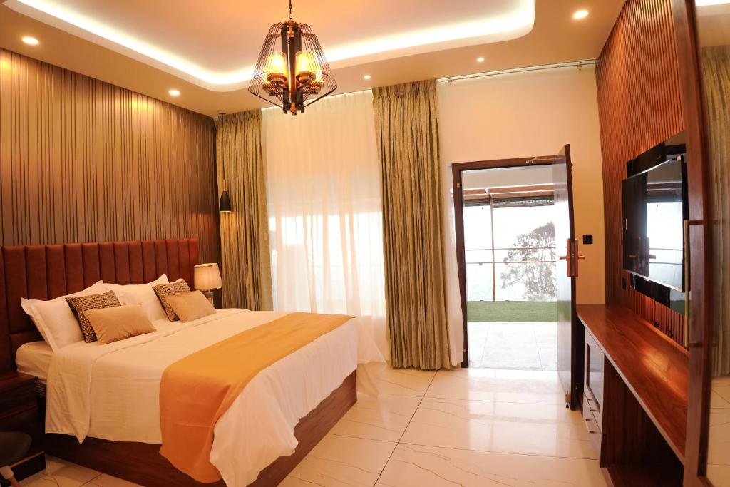 1 dormitorio con 1 cama grande y TV en Misty Wonders en Munnar