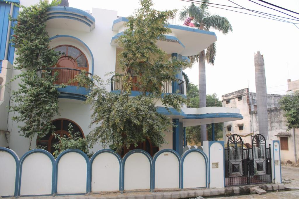 a white building with blue trim and a fence at Shiva INN in Varanasi