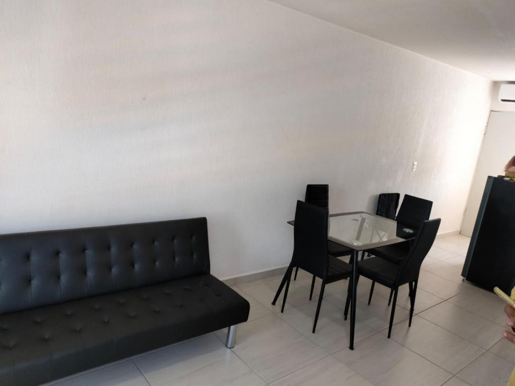 ein Esszimmer mit einem Sofa, einem Tisch und Stühlen in der Unterkunft Apartamento Cadereyta 